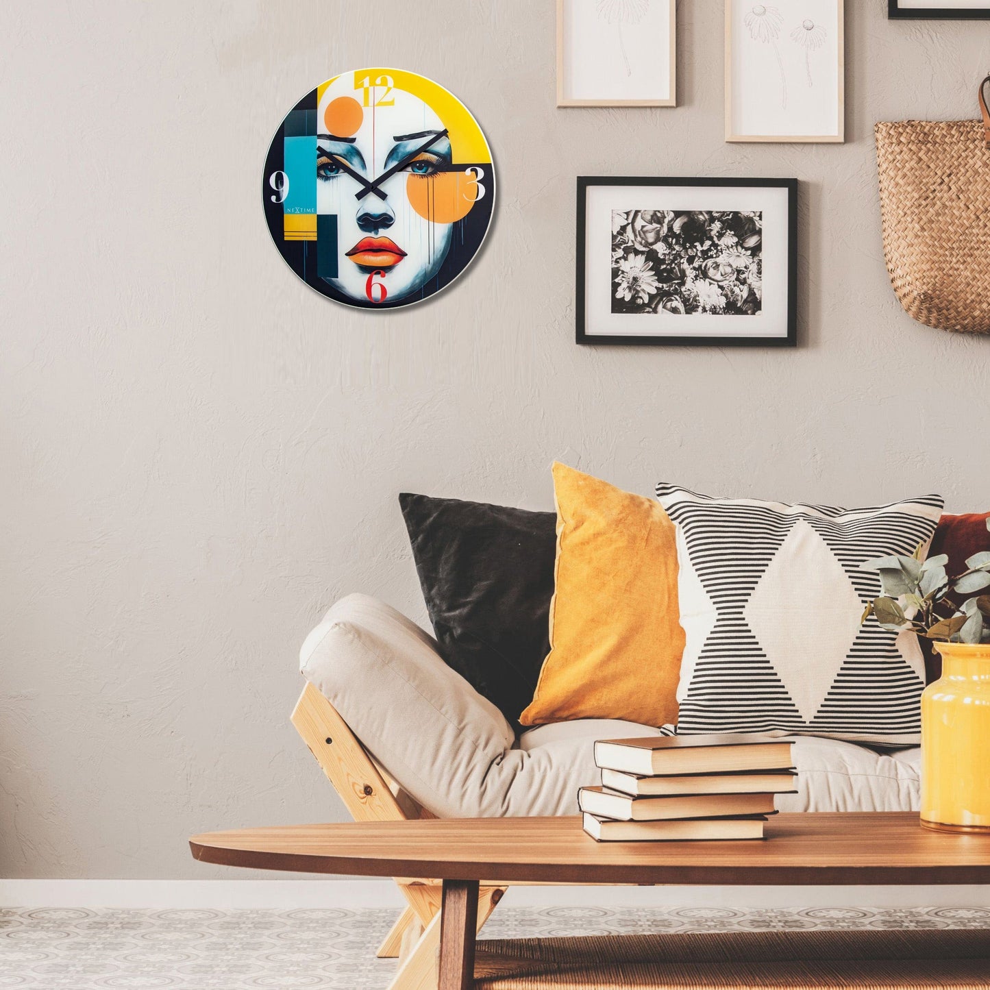 Een kleurrijke wandklok met een abstracte vrouwengezichtsontwerp, waarbij heldere gele, blauwe en oranje accenten op een witte achtergrond staan. De klok heeft zwarte wijzers en grote cijfers voor duidelijke leesbaarheid in woonkamers of kantoren.