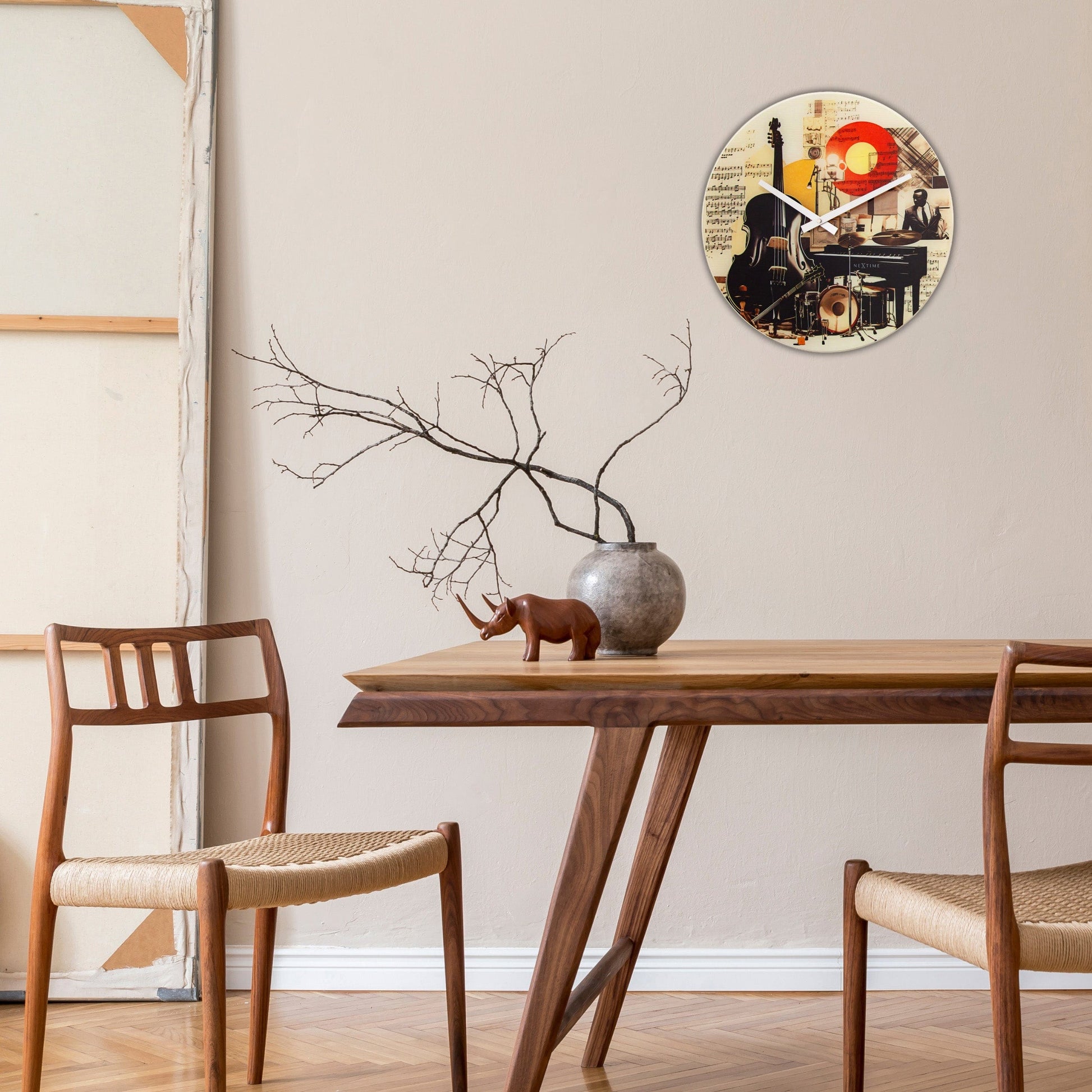 Een ronde wandklok met een kleurrijke collage van muziekinstrumenten, muzieknoten en een jazzmuzikant. Perfect voor een muziekrkamer of studio als decoratief stuk.
