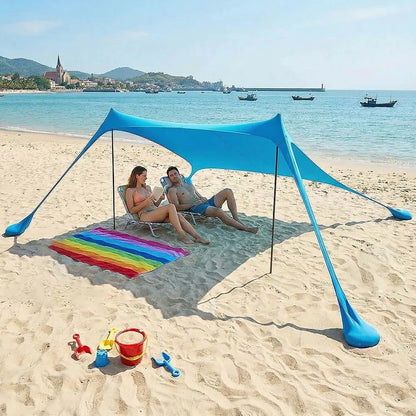 Blauwe zonnescherm tent op het strand, met vier personen die genieten van de zon. Grote, lichtblauwe tent met zichtbare stokken en een regenboogkleuri