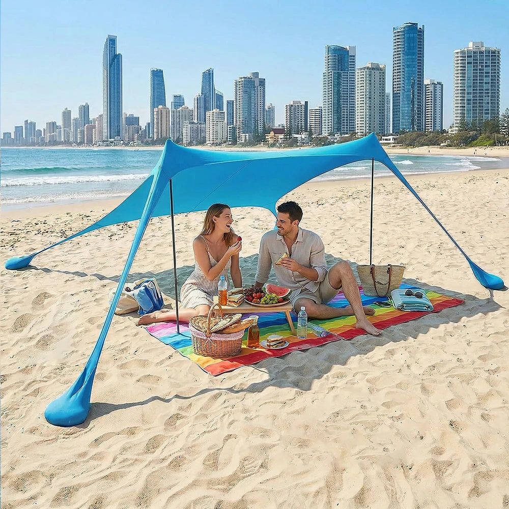 Blauwe zonnescherm tent op het strand, met vier personen die ontspannen op kleurrijke dekens. Ideaal voor zonbescherming tijdens strand- en picknickac