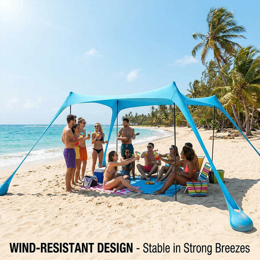 Blauwe zonneschaduw tent op het strand, met vier personen die genieten van de zon. Kleurrijke strandmat en accessoires versterken de zomervakantie sfe