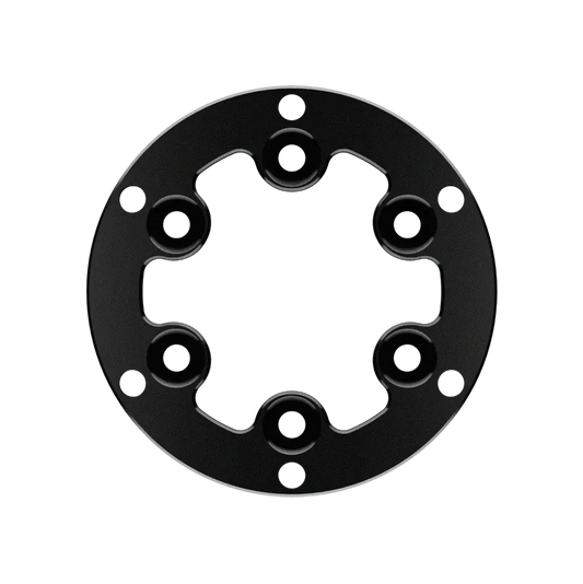 Zwart metalen montageplaat met zeshoekige opening en acht schroefgaten, geschikt voor camera’s en drones. Gebruik als montagebasis voor professionele videoproduktie.