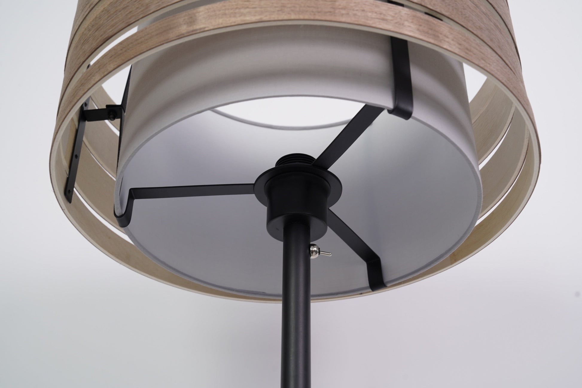 Een moderne, zwarte vloerlamp met een gestreepte, witte kap en een dunne steel, ideaal voor minimalistische interieurs. Perfect voor woonkamer- of slaapkamerverlichting.