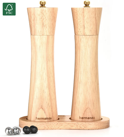 Houten pepermolen en zoutmolen van Hermanos, met goudkleurige doppen en FSC-keurmerk, geplaatst op een houten standaard met vervangbare doppen voor keukengereedschap.