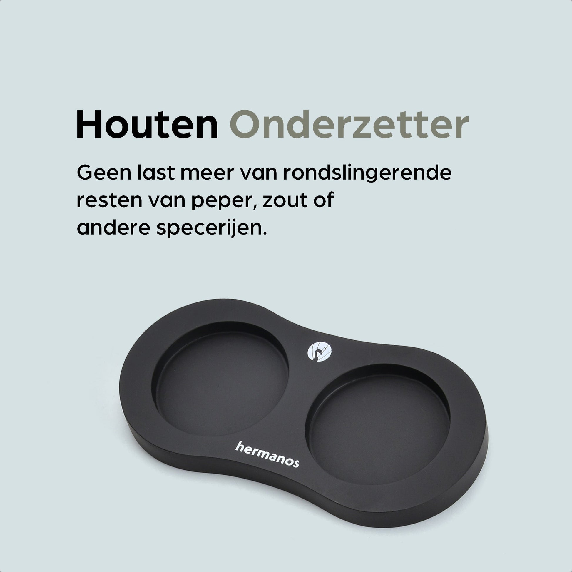 Zwarte houten pepermolen en zoutmolen met goudkleurige doppen, geplaatst op een zwarte standaard met het merk 'hermanos'. Inclusief vier vervangende doppen voor keukengebruik.