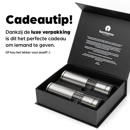 Zilverkleurige Hermanos elektrische pepermolen en zoutmolen met transparante cilinders, gevuld met kleurrijke peperkorrels en roze zout. Ideaal voor moderne keukens en gourmet kookplekken.