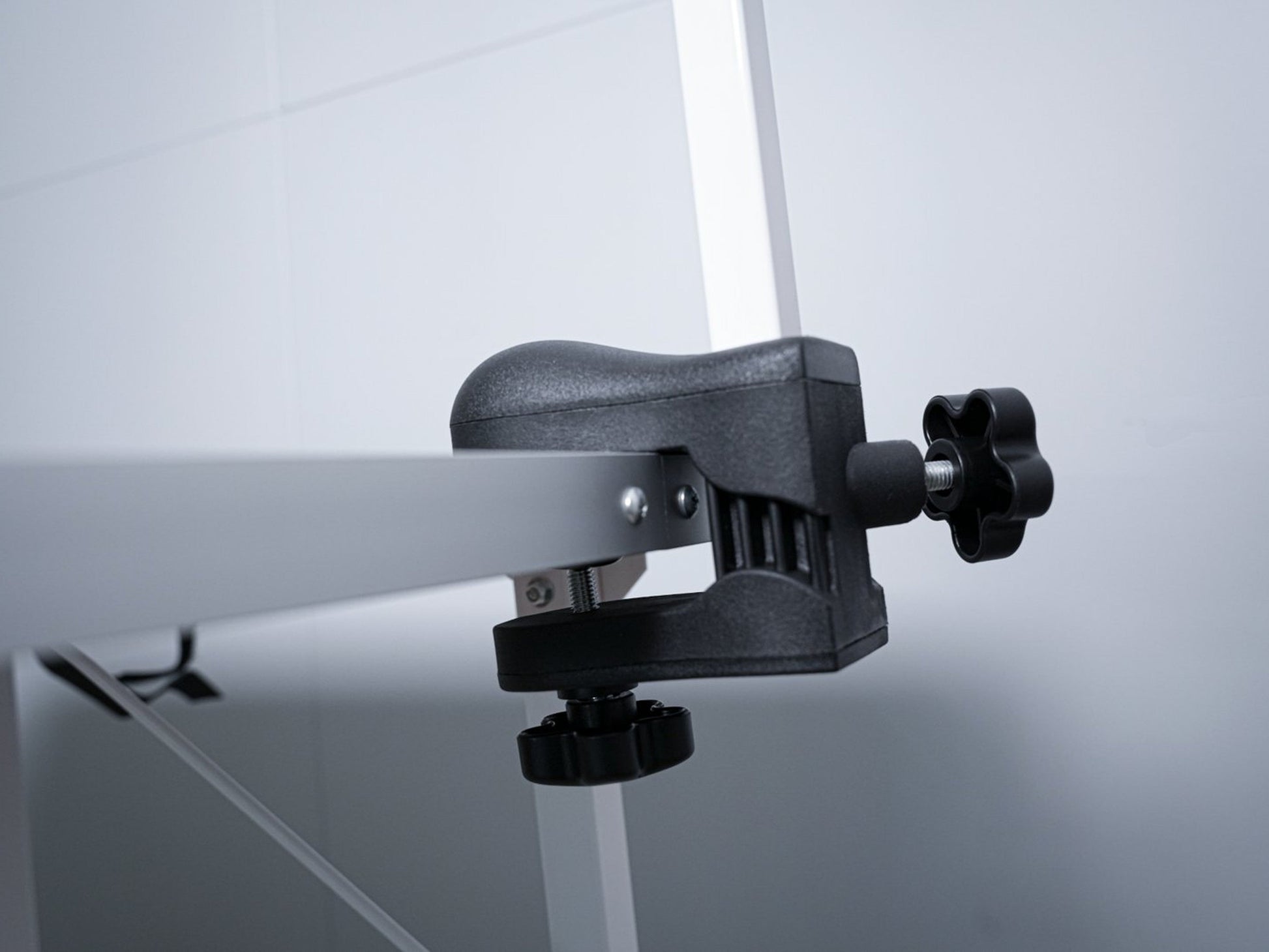 Een witte, opvouwbare hondensnijtafel met zwarte oppervlakte en twee hangende riemen, geschikt voor professionele hondensnijden en -verzorging in huis of studio.