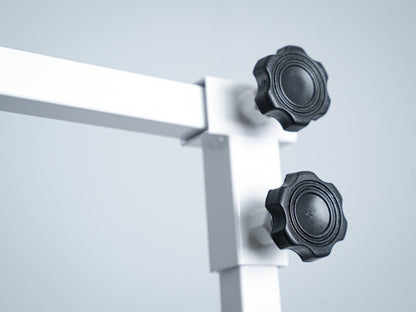 Een witte, vouwbare hondensnijtafel met zwarte oppervlakte en twee halsbandhangers, geschikt voor professionele hondensnijden en -verzorging in huis of studio.