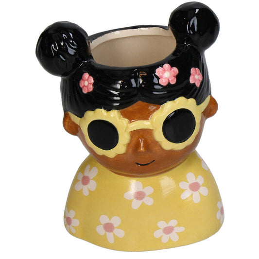 Een kleurrijke keramische plantenpot in vorm van een vrouw met zonnebril en bloemenjurk, gevuld met een groene varen. Perfect voor een stijlvolle interieurbloempot of decoratieve plantenverzorging.
