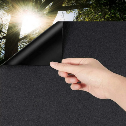 Zwart glasfolie op een wit raamkozijn, zacht mat en volledig lichtdicht, perfect voor privacy en zonbescherming in woon- of kantoorruimtes.