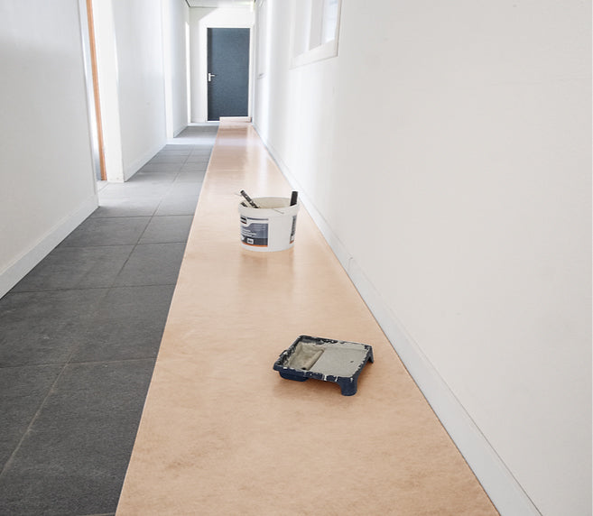 Een rol beige Perfect Cover beschermfolie, met duidelijke merkverpakking en gebruiksaanwijzingen, geschikt voor tijdelijke bescherming van meubels en vloeren tijdens renovaties of huishoudelijke werkzaamheden.