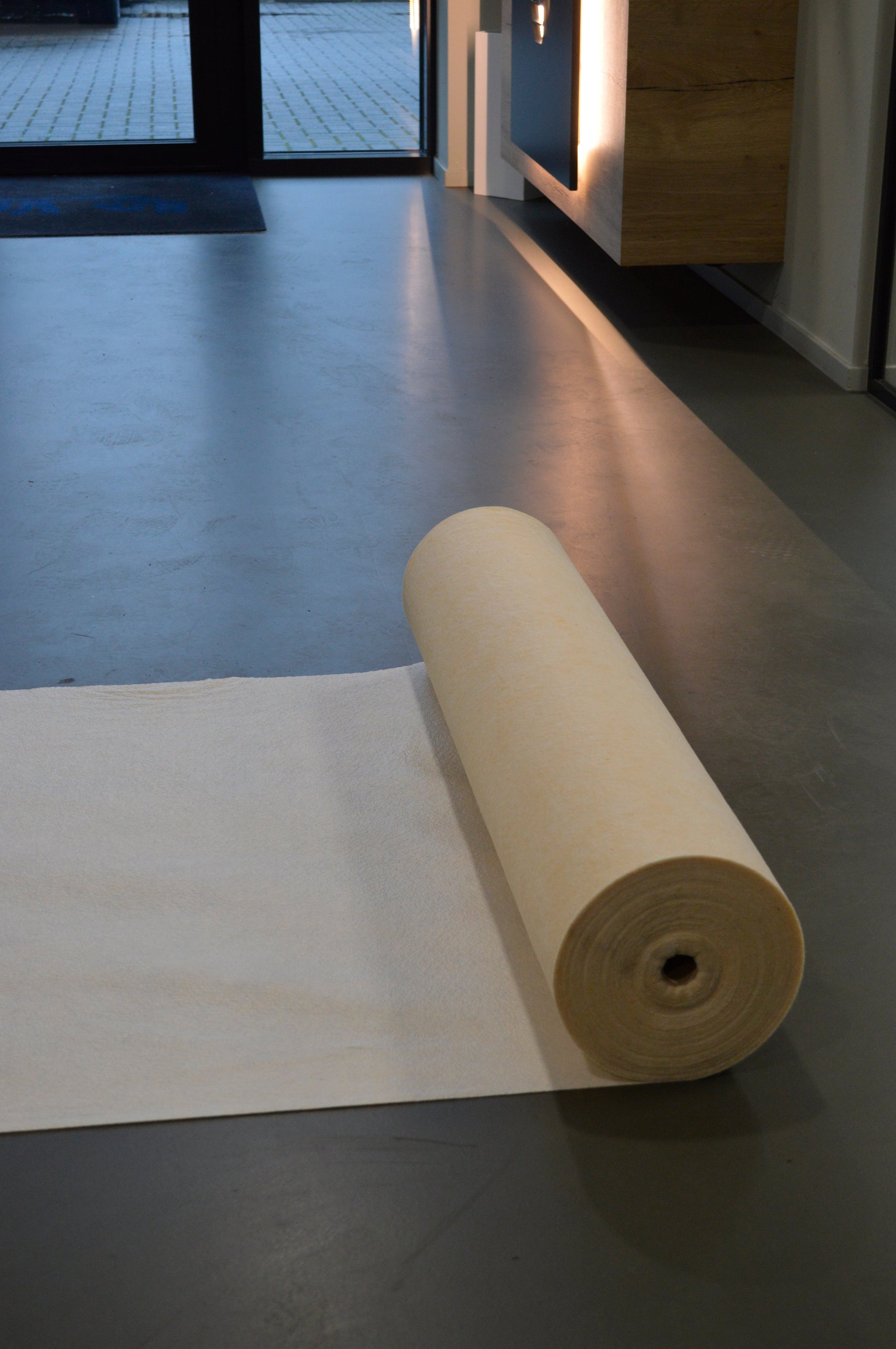 Een rol beige Perfect Cover beschermfolie, met duidelijke merkverpakking en gebruiksaanwijzingen, geschikt voor tijdelijke bescherming van meubels en oppervlakken tijdens renovaties of evenementen.