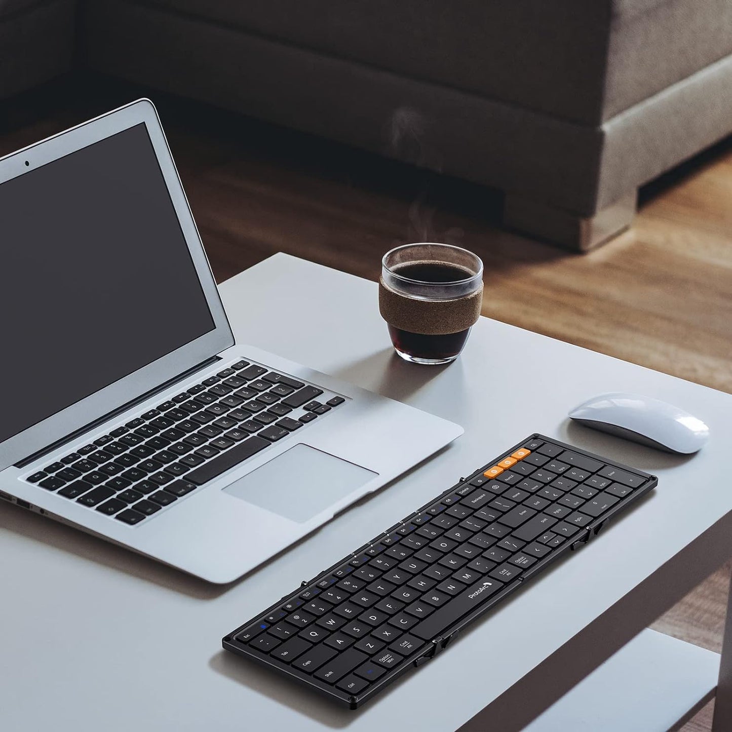 Zwart, vouwbare toetsenbord met flexibele, opvouwbare constructie en oranje functietoetsen, geschikt voor mobiele werking en reizen. Compact ontwerp voor gebruik met tablets en smartphones.