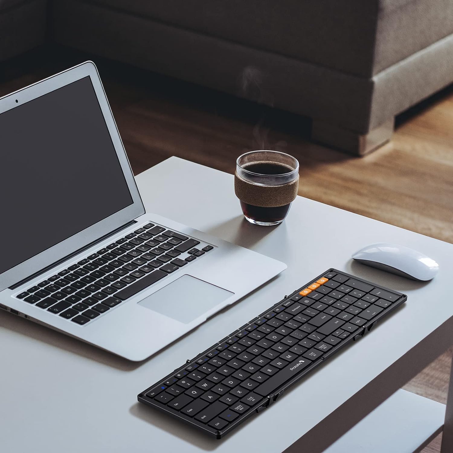 Zwart, vouwbare toetsenbord met flexibele, opvouwbare constructie en oranje functietoetsen, geschikt voor mobiele werking en reizen. Compact ontwerp voor gebruik met tablets en smartphones.