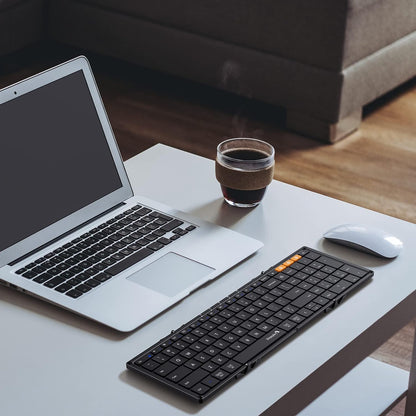 Zwart, vouwbare toetsenbord met flexibele, opvouwbare constructie en oranje functietoetsen, geschikt voor mobiele werking en reizen. Compact ontwerp voor gebruik met tablets en smartphones.