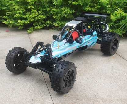 Groene camouflage RC buggy met zwarte banden en metalen frame, klaar voor terreinrijden. Zichtbare motor en stuurwiel, geschikt voor outdoor speelplek