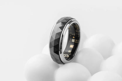 Een COLMi slimme ring met glanzend zilveren rand en facettenstructuur, voorzien van een actieve sensor en groene LED-indicator, geschikt voor dagelijks gebruik en technologische toepassingen. - Foto 30