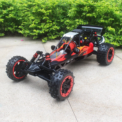 Groene camouflage RC buggy met zwarte banden en metalen frame, klaar voor terreinrace. Zichtbare motor en stuurkolom, geschikt voor outdoor speelplein