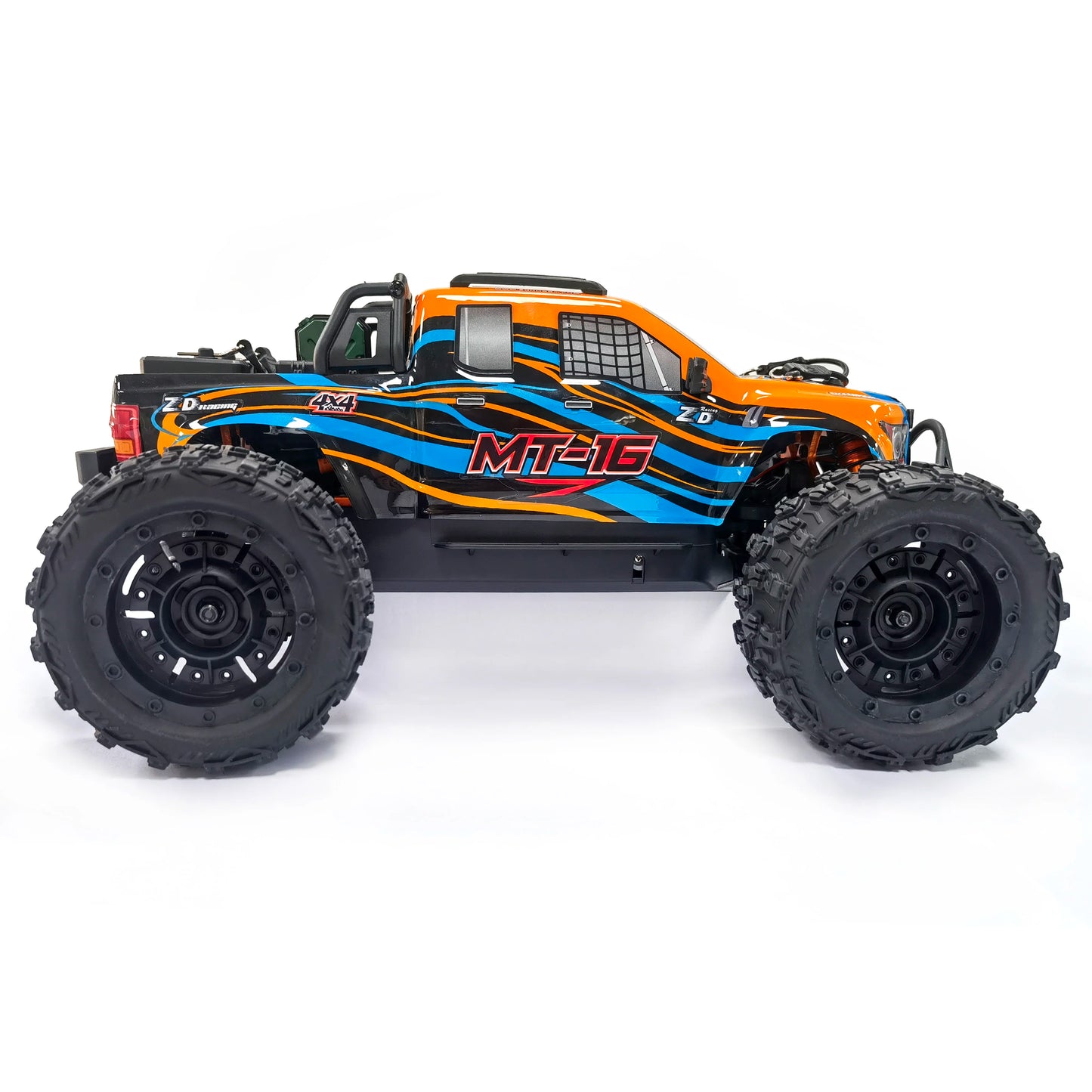 Oranje en blauwe RC monstertruck met grote zwarte banden en zichtbare 'MT-16' sticker, geplaatst naast zijn zwarte stuurunit voor speelplezier op zand