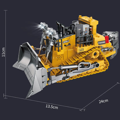 Grote gele, graafmachine en bulldozer met zwarte details, staan op zand. Een hand houdt de bijbehorende controller vast voor speelgoedbouwplaatsen. - 
