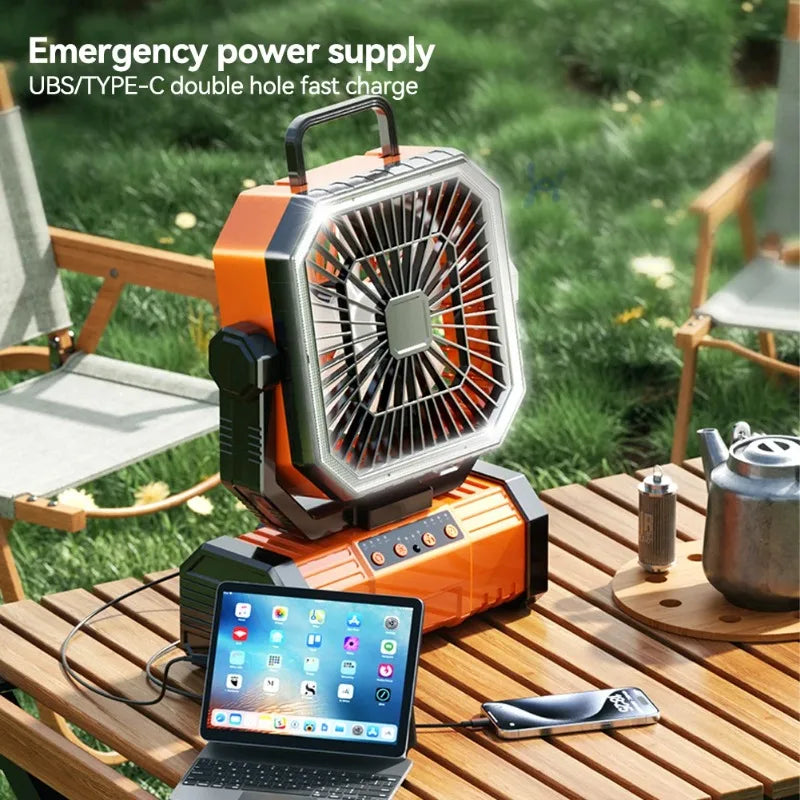 Oranje noodstroomvoorziening met USB-C oplaadpoorten, geplaatst op een houten tafel in een tuin. Laadt tablet en smartphone tijdens kamperen of buiten
