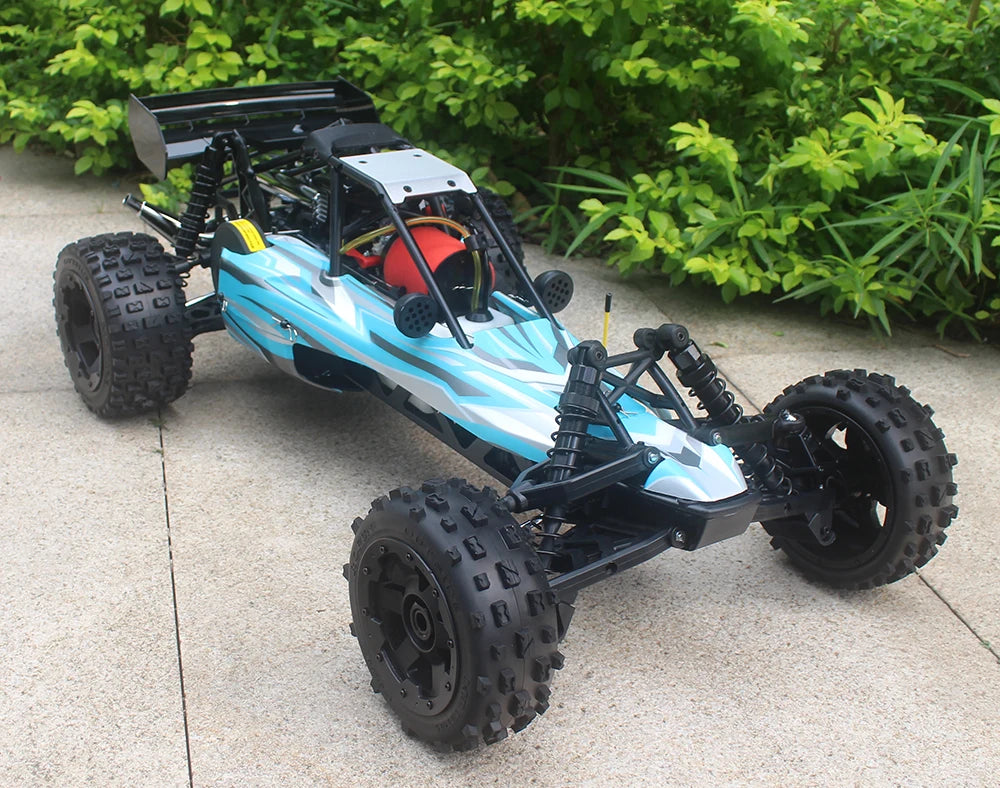 Groene camouflage RC-buggy met zwarte banden en metalen frame, klaar voor terreinrijden. Zichtbare motor en stuurwiel op beton, perfect voor buitenver