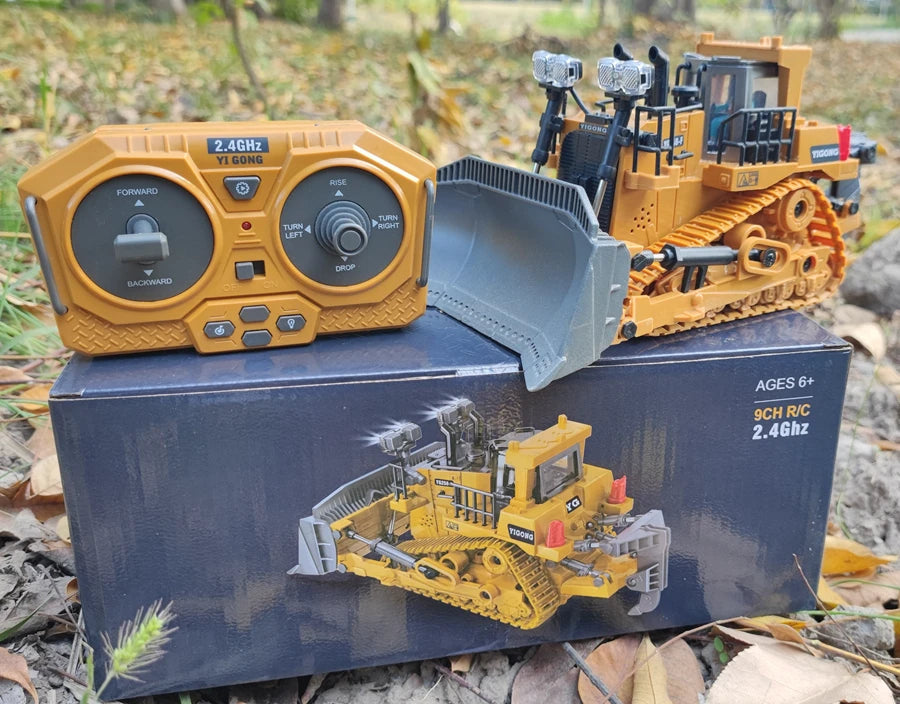 Grote, realistische RC-graafmachine in zwart en geel, met zichtbare trekkerbanden en een schep die zand opvangt. Inclusief afbeeldingen van de control