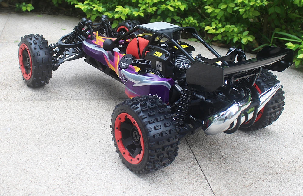 Groene camouflage RC buggy met zwarte banden en metalen frame, klaar voor terreinrijden. Zichtbare motor en stuurwiel op beton, perfect voor buitenple