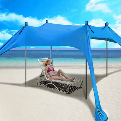 Blauwe zonnescherm tent met metalen stokken biedt schaduw op het strand. Een vrouw in bikini en strohoed rust op een ligstoel onder de tent, perfect v