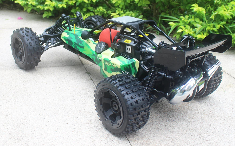 Groene camouflage RC-buggy met zwarte banden en metalen frame, klaar voor terreinrijden. Zichtbare motor en stuurkolom, ideaal voor outdoor speelplekk