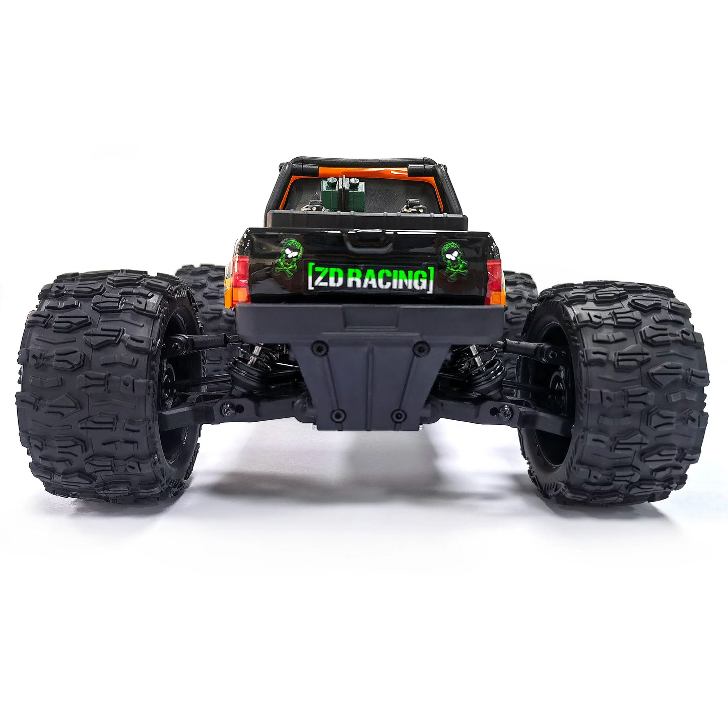 Oranje en blauw gestreepte RC monstertruck met grote zwarte banden en zichtbare "MT-16" sticker, geplaatst naast zijn zwarte stuurunit voor terreinrij