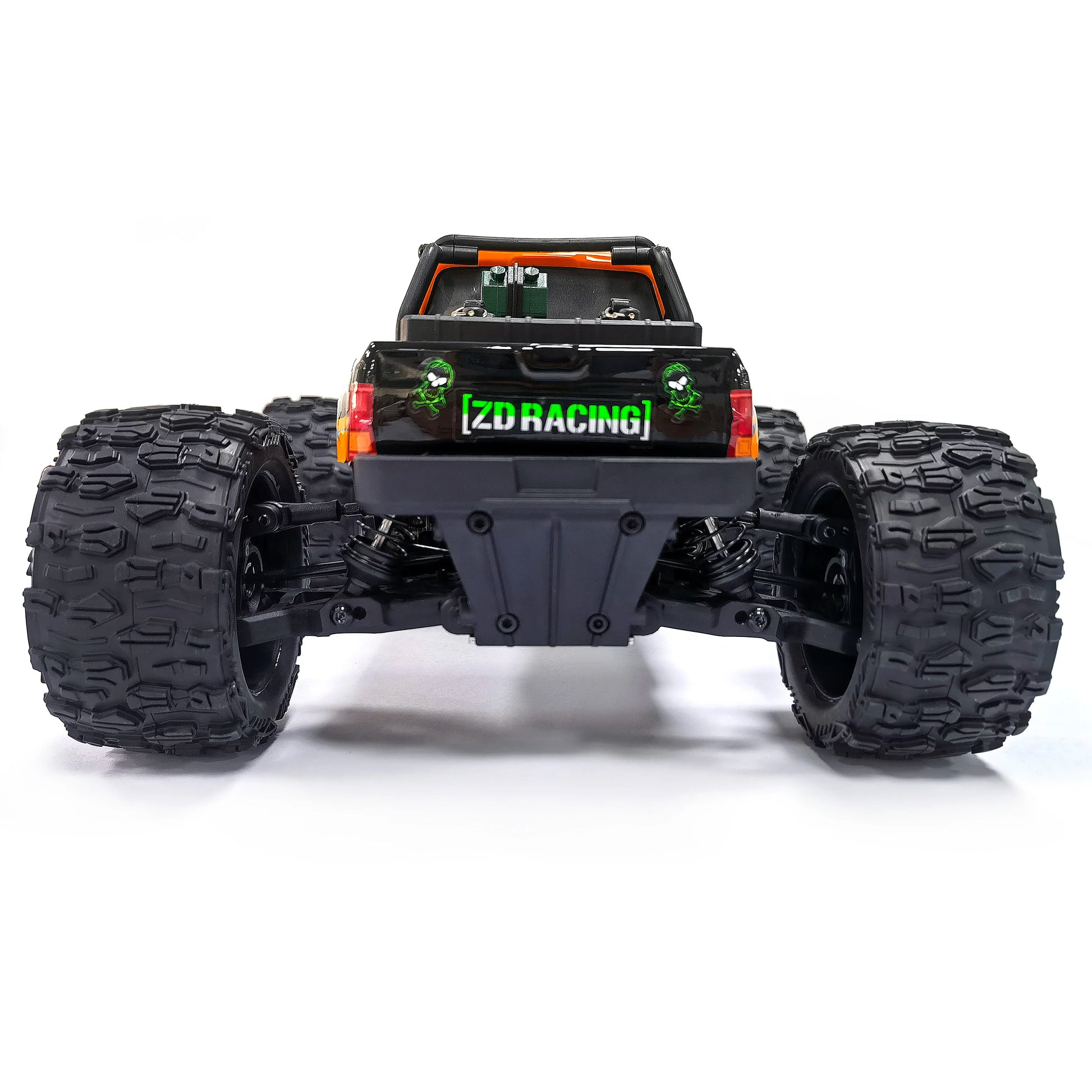 Oranje en blauw gestreepte RC monstertruck met grote zwarte banden en zichtbare "MT-16" sticker, geplaatst naast zijn zwarte stuurunit voor terreinrij