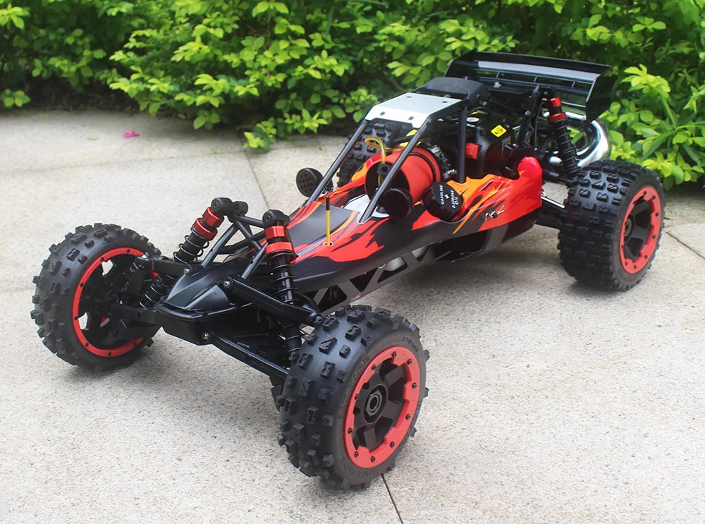 Groene camouflage RC-buggy met zwarte banden en metalen frame, klaar voor terreinrijden. Zichtbare motor en stuurwiel op beton, perfect voor buitenple
