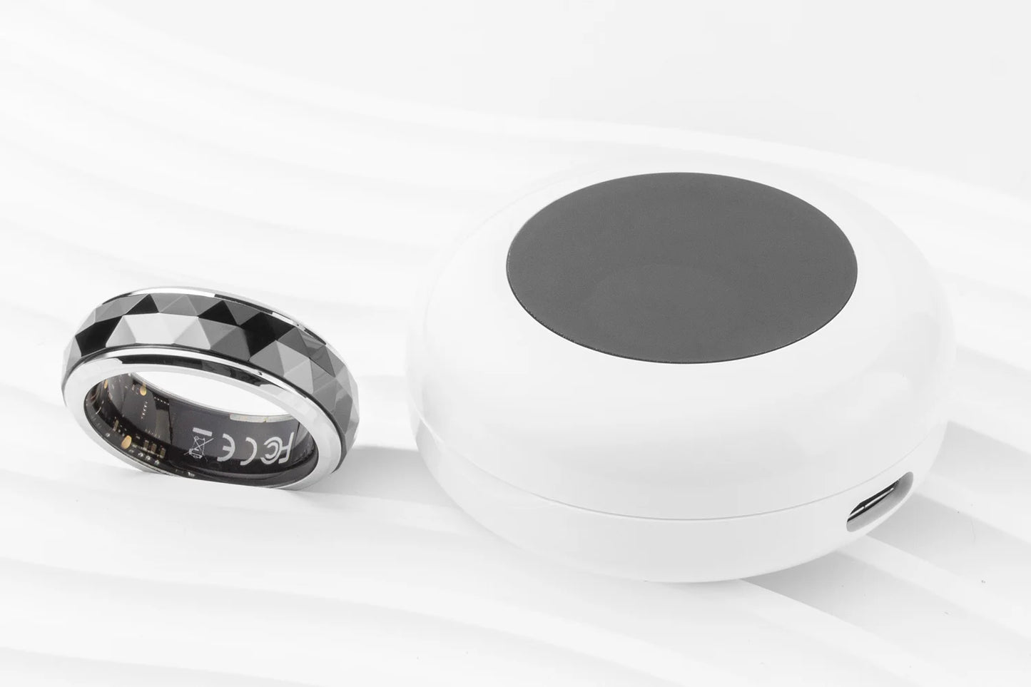 Een COLMi slimme ring met glanzend zilveren rand en facettenstructuur, voorzien van een actieve sensor en groene LED-indicator, geschikt voor dagelijks gebruik en sportactiviteiten. - Foto 28