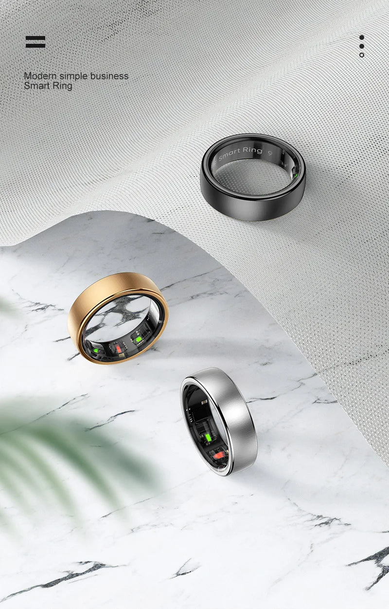 Een zilverkleurige slimme ring met een gestreepte textuur en groene LED-indicatoren, naast een gouden variant op een draadloze oplader met blauwe lichtcirkels, speciaal ontworpen voor slimme ringen en gezondheidsmonitoren. - Foto 21