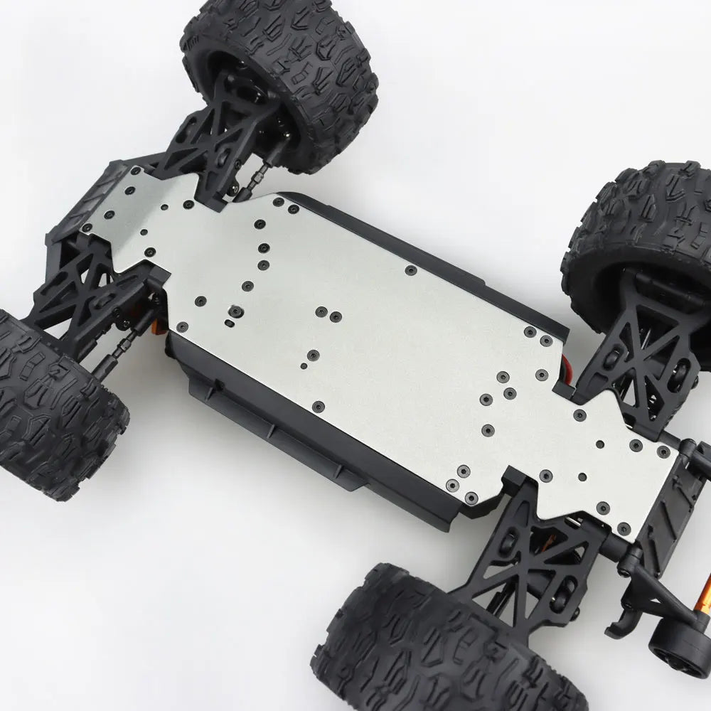 Oranje en blauwe RC monstertruck met grote zwarte banden en zichtbare "MT-16" sticker, geplaatst naast zijn zwarte stuurcontroller voor speelplezier o