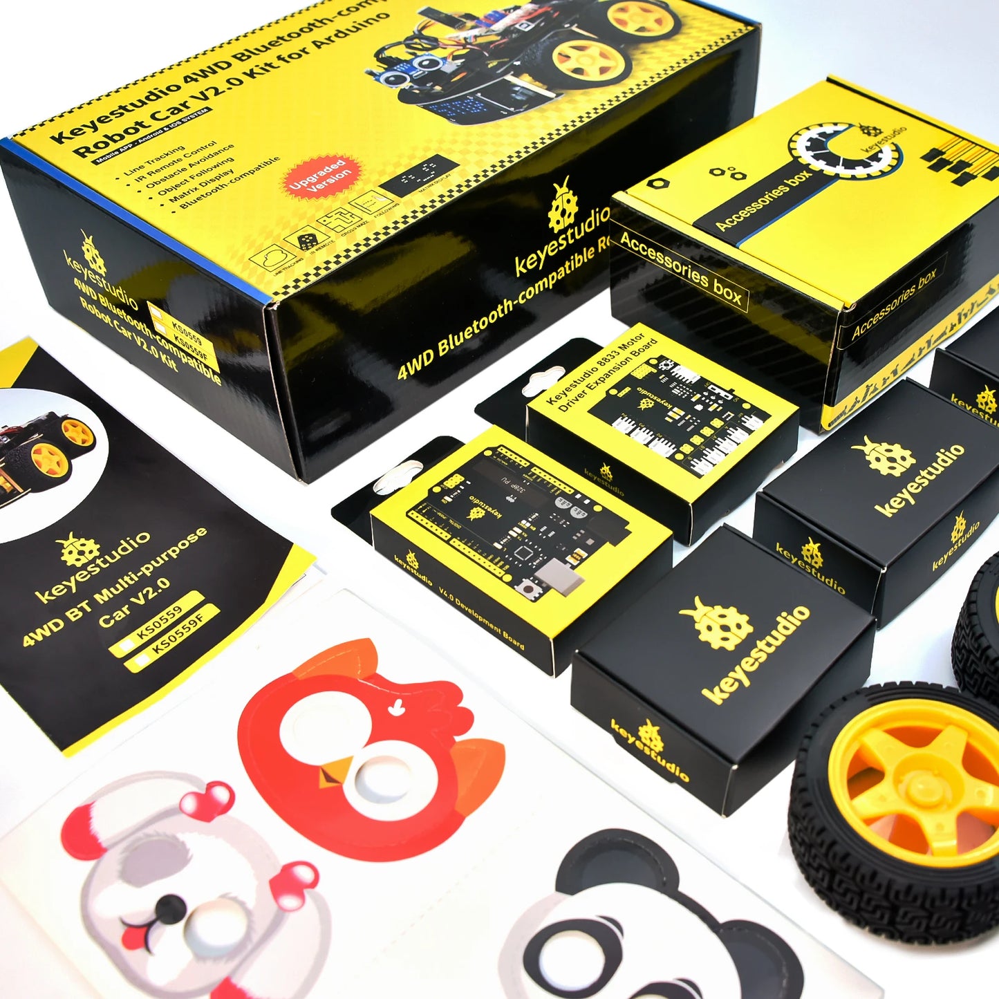 Een Keyestudio robotkit met zwarte chassis, gele wielen en diverse elektronische componenten, inclusief sensoren en een microcontroller, voor educatie