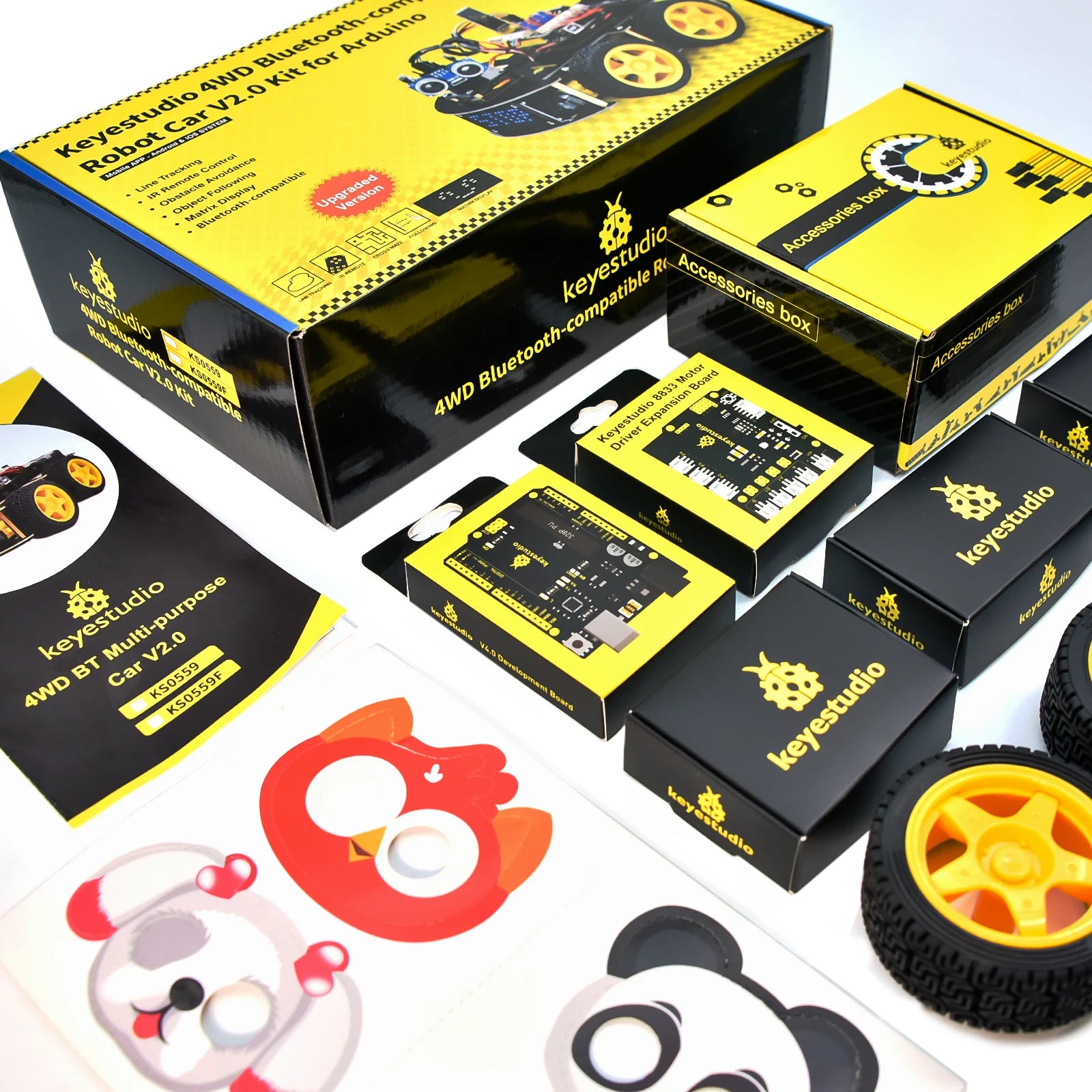 Een Keyestudio robotkit met zwarte chassis, gele wielen en diverse elektronische componenten, inclusief sensoren en een microcontroller, voor educatie