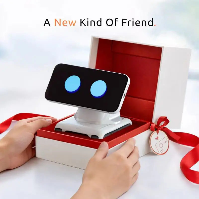 Een zwarte LOOI AI-robot met blauwe ogen, geplaatst op een magnetisch standaard voor smartphones. Ideaal als desktop-assistent voor Android en iOS geb