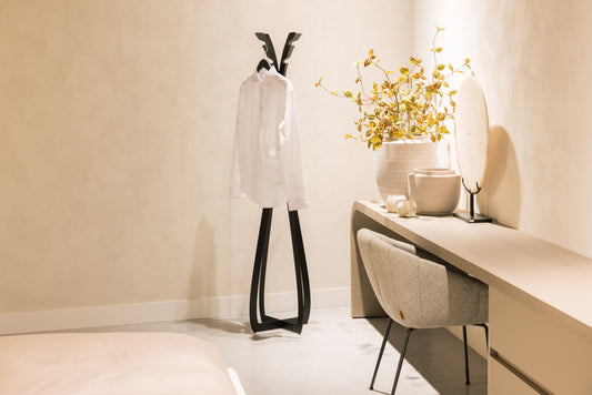 Een zwart, minimalistisch jasstandaard van metaal met een elegante, dunne vorm en twee opstaande hangers. Geschikt voor moderne interieurs en als opbergoplossing in woon- of kantoorruimtes.