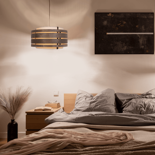 Een moderne wandlamp met donker houten ringen en crèmekleurige stof, geschikt voor woonkamer of slaapkamer. Stijlvol design met natuurlijk hout en minimalistische lijnen voor een warme, rustige sfeer.