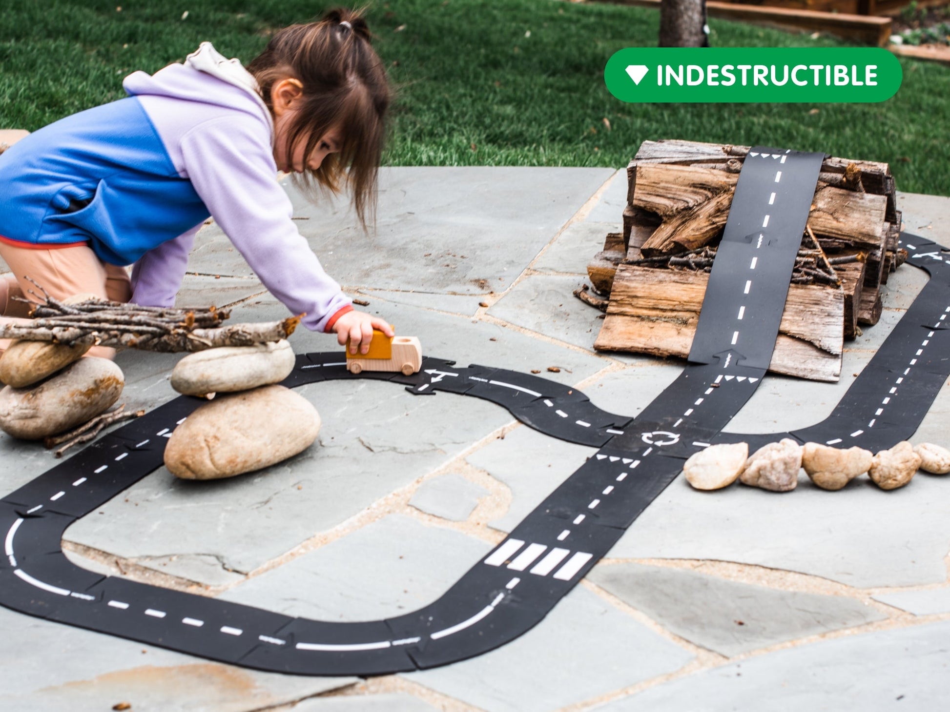 Zwart houten wegplaatjes met witte verkeersmarkeringen, inclusief een houten auto, voor creatieve speelplekken. Ideaal voor kinderen om hun eigen verkeersroutes te bouwen.