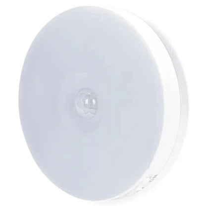 Een witte, ronde bewegingssensor met glazen lens, geschikt voor nachtlicht en veiligheid. Compacte, moderne ontwerp voor binnenruimtes en tuinverlichting.