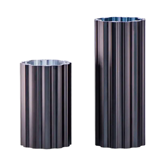 Zilverkleurige, verticaal geribbelde aluminium buisjes met een glanzende, reflecterende oppervlakte. Geschikt voor decoratieve installaties of als onderdeel van architectonische constructies.