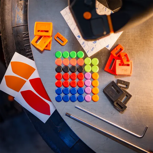 Een kleurrijke set van plastic bouwstukken in rood, blauw, groen, paars en oranje, inclusief een zwarte tool en stickers, speciaal ontworpen voor kinderen om creatieve speelgoedconstructies te bouwen.