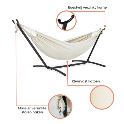 Een crèmekleurige hangmat met witte kabels hangt op een zwart metalen frame, ideaal voor ontspanning in de tuin of op het terras.