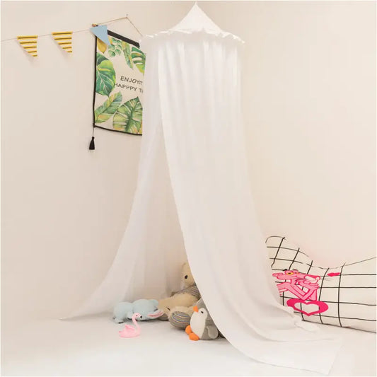 Een witte, lichte kindermoskitonkel met ruches hangt boven een speelkleed, omringd door knuffels en een gestreept kussen. Perfect voor een kinderkamer met een tropisch thema.