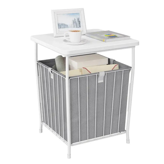 Een witte opbergtafel met een grijze stoffen mand, geschikt voor kantoor- of woonruimte. De tafel draagt een koffiekopje en een fotolijst, terwijl de mand boeken en kantoorbenodigdheden opbergt.