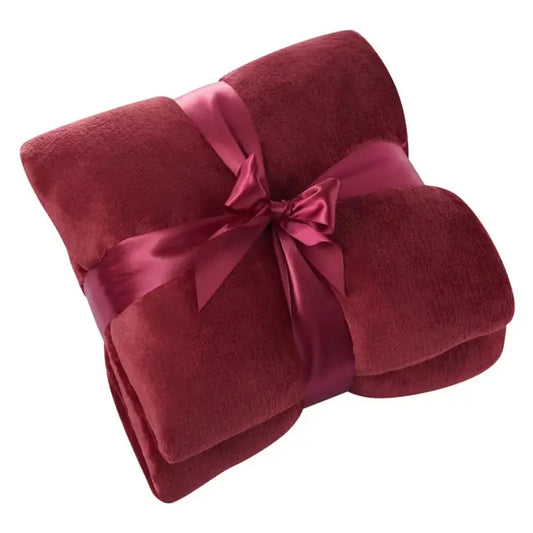 Rode, fluweelachtige deken met een glanzende paarse strik, perfect voor een luxe cadeau. Ideaal voor comfort en een feestelijke sfeer in de woonkamer of slaapkamer.