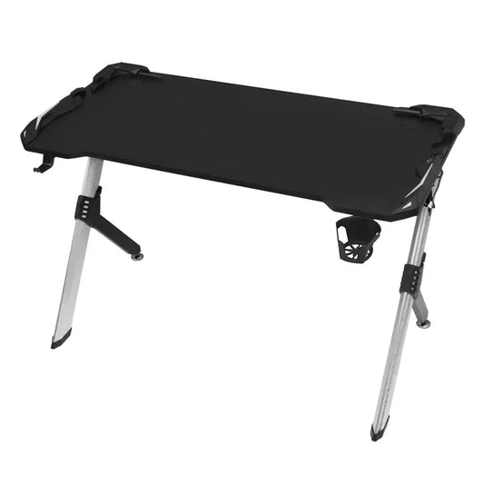 Ergonomische gamingtafel met zwart oppervlak en zilveren poten, uitgerust met twee schermen, toetsenbord, speakers en oortjes. Ideaal voor gamers die comfort en stijl combineren tijdens hun sessies.
